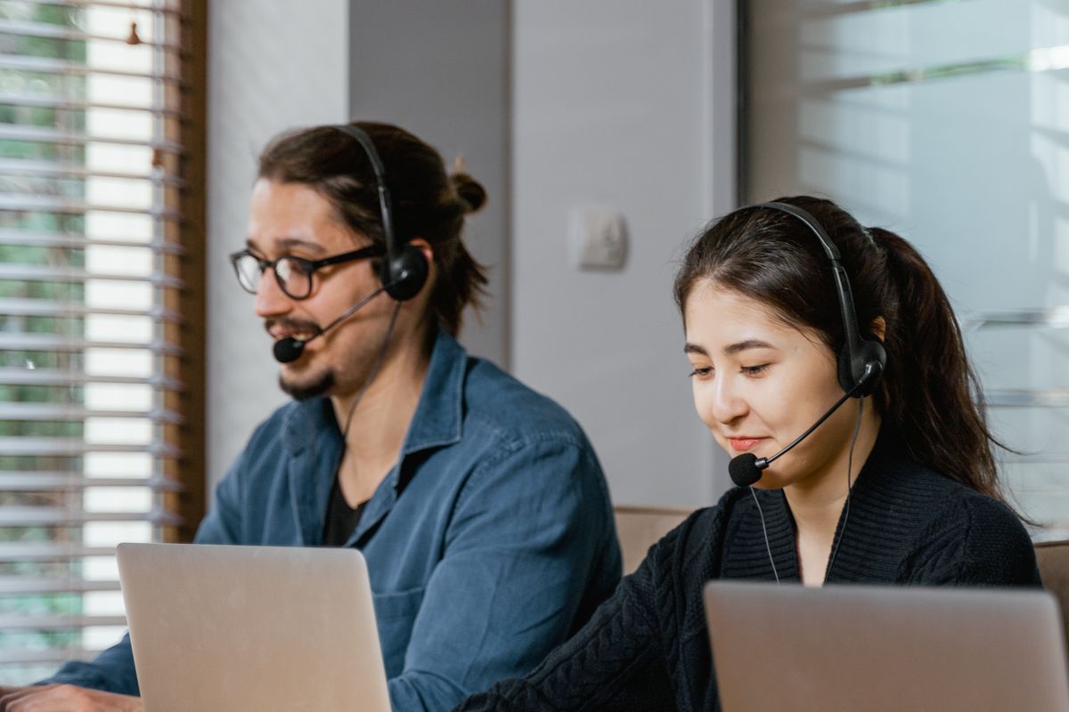 Two people working with headsets on