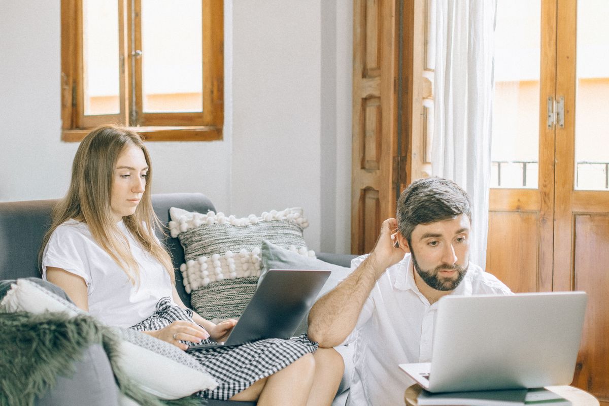 Two people working on laptops from home