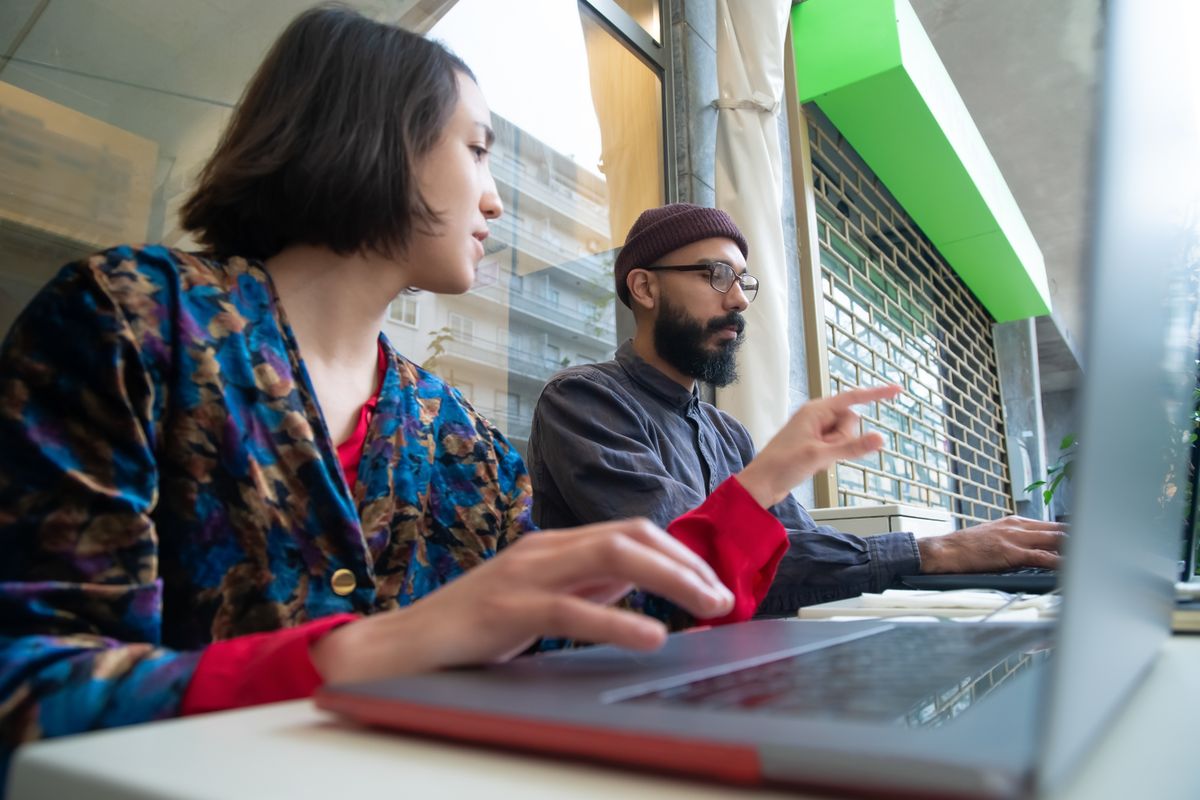 Two colleagues going through work on a laptop